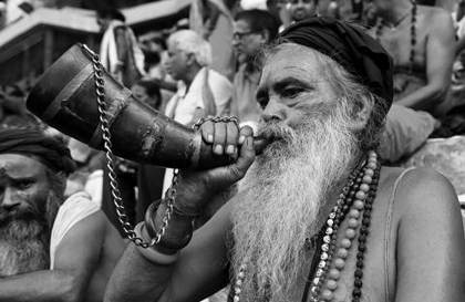 A sadhu sounds a horn at the Ambubachi Mela