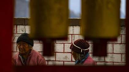 Nuns glimpsed between the prayer wheels